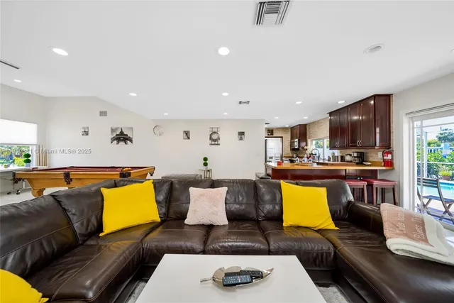 a living room with furniture and kitchen view
