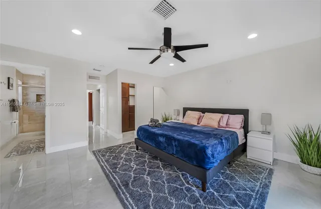 a bedroom with a large bed and a chandelier