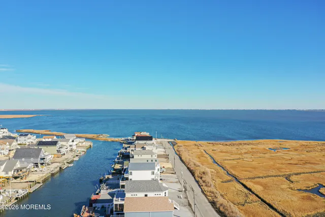an aerial view of residential houses with outdoor space and ocean view