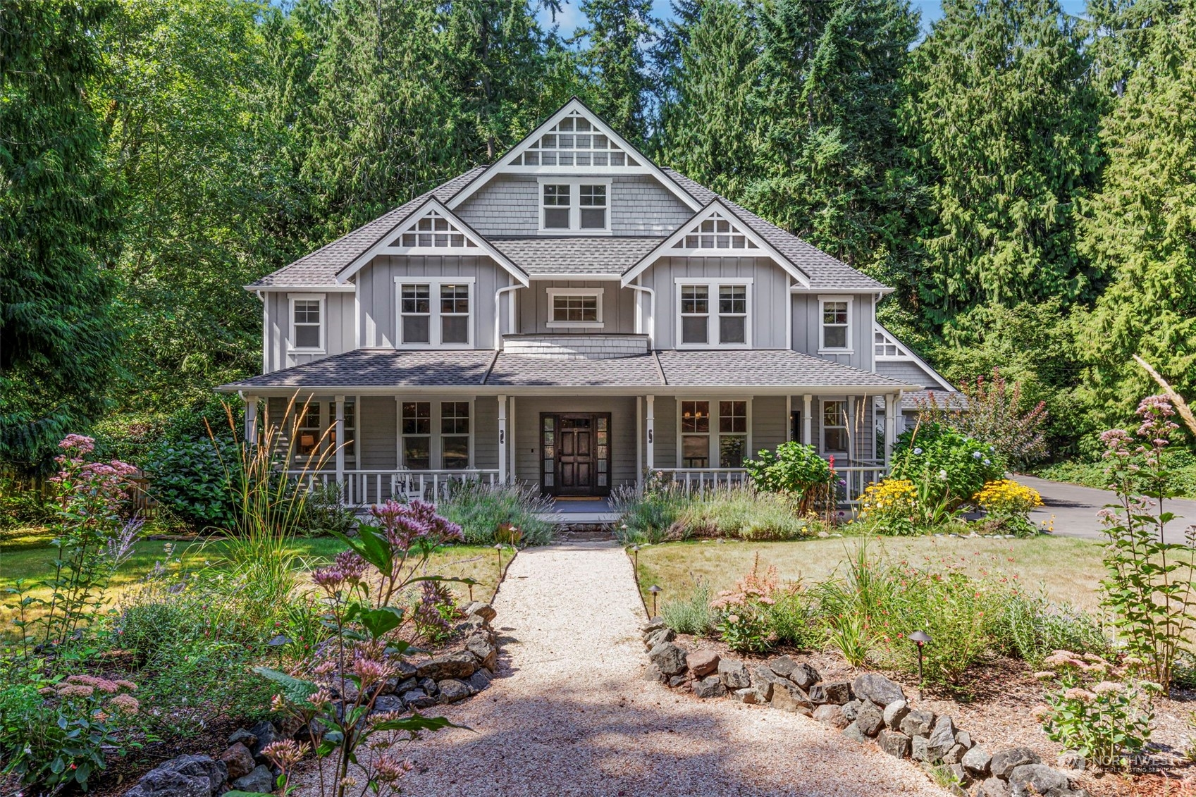 6457 Haley Loop Road Northeast Bainbridge Island, WA 98110 - Photo 1 of 40 a front view of a house with a yard and potted plants