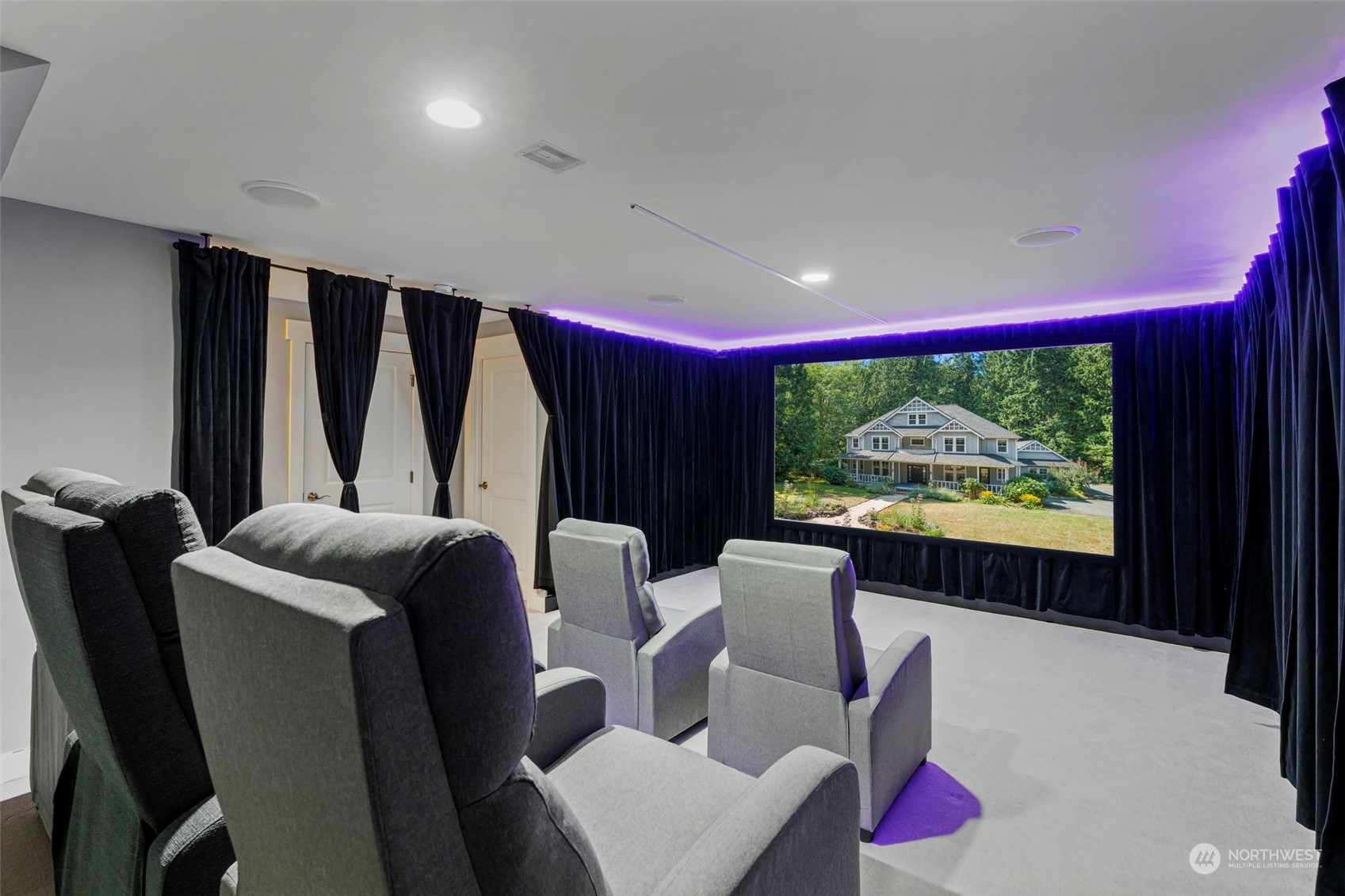 6457 Haley Loop Road Northeast Bainbridge Island, WA 98110 - Photo 23 of 40 a living room with furniture a projector and a large window