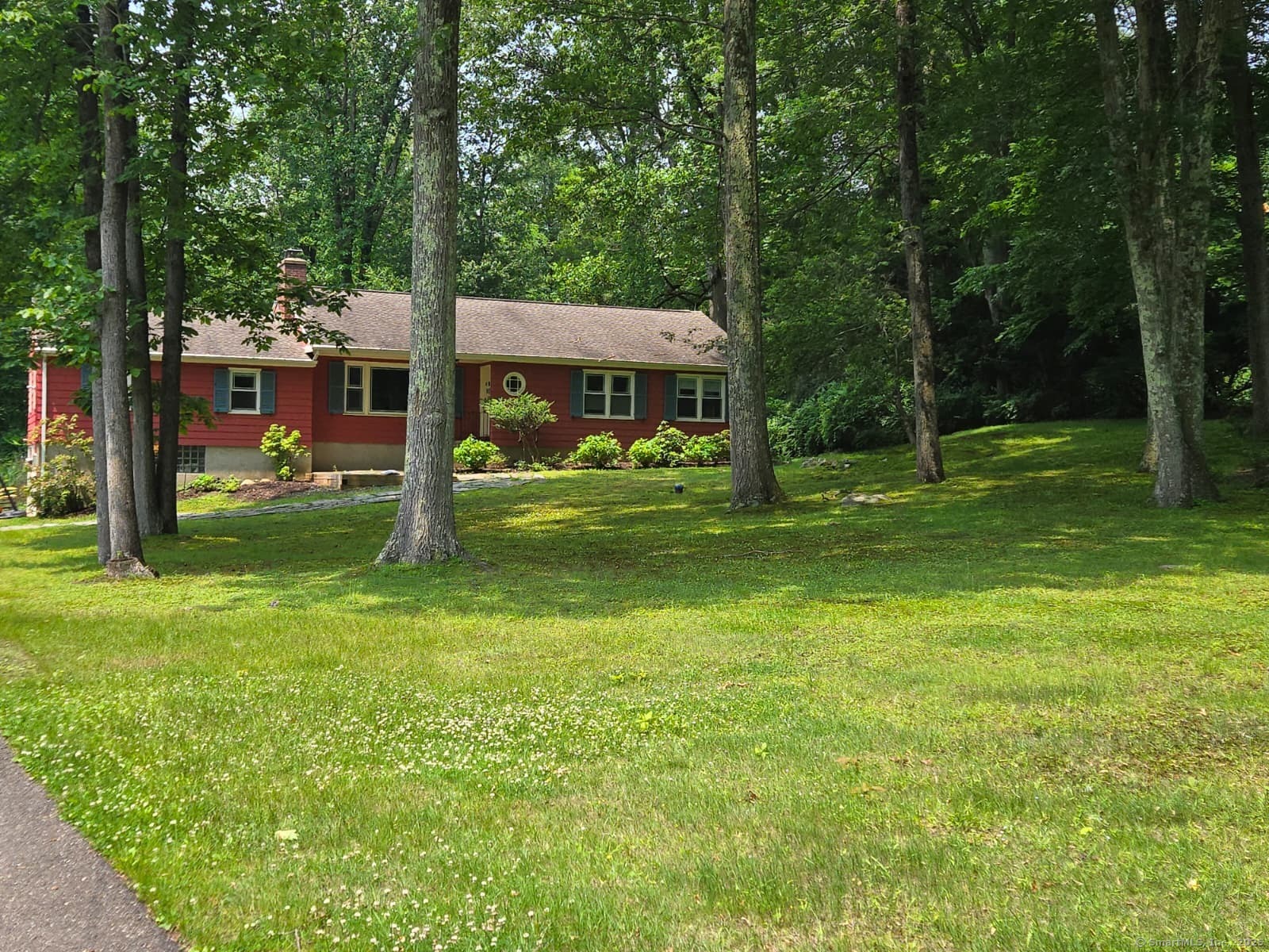 a view of a house with a big yard and large trees