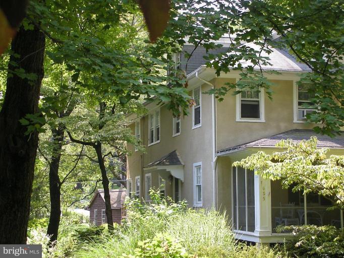 a yellow house with trees in front of it