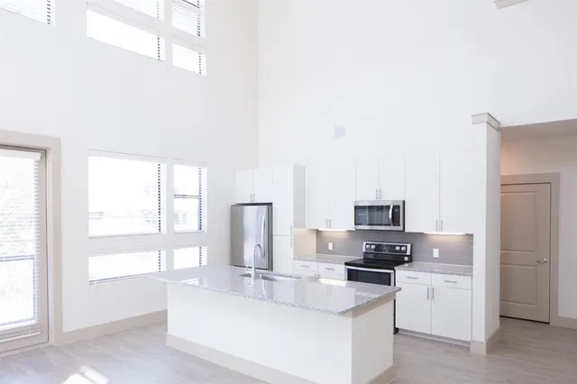 a kitchen with white cabinets and appliances