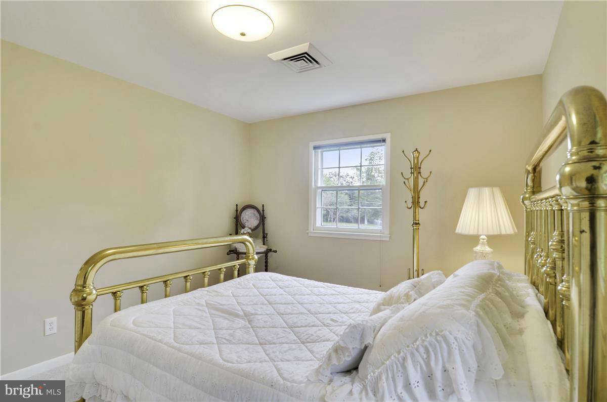 2117 Apple Tree Lane Silver Spring, MD 20905 - Photo 18 of 30 a bedroom with a bed and a chandelier
