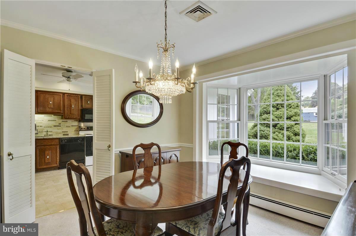 2117 Apple Tree Lane Silver Spring, MD 20905 - Photo 6 of 30 a view of a dining room with furniture a chandelier and large windows