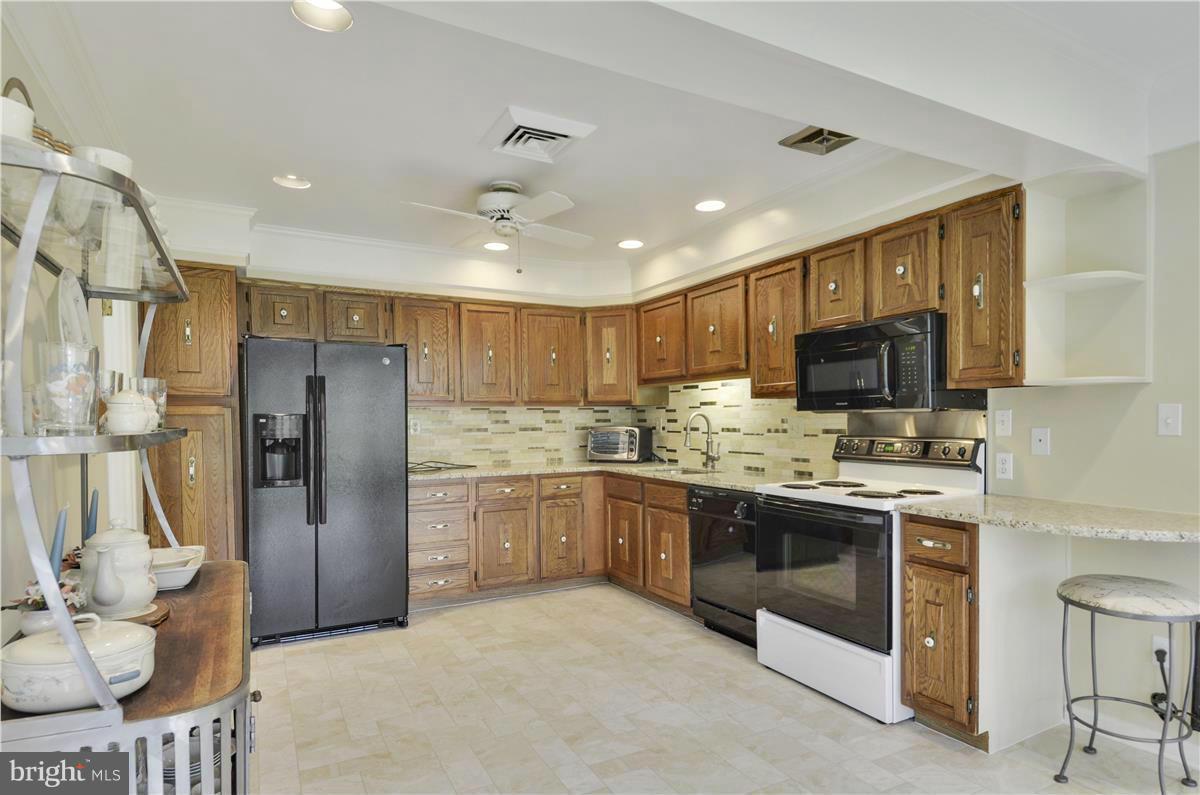 2117 Apple Tree Lane Silver Spring, MD 20905 - Photo 10 of 30 a kitchen with stainless steel appliances granite countertop a refrigerator stove top oven and sink