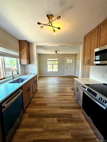 a large kitchen with stainless steel appliances granite countertop a stove and a sink