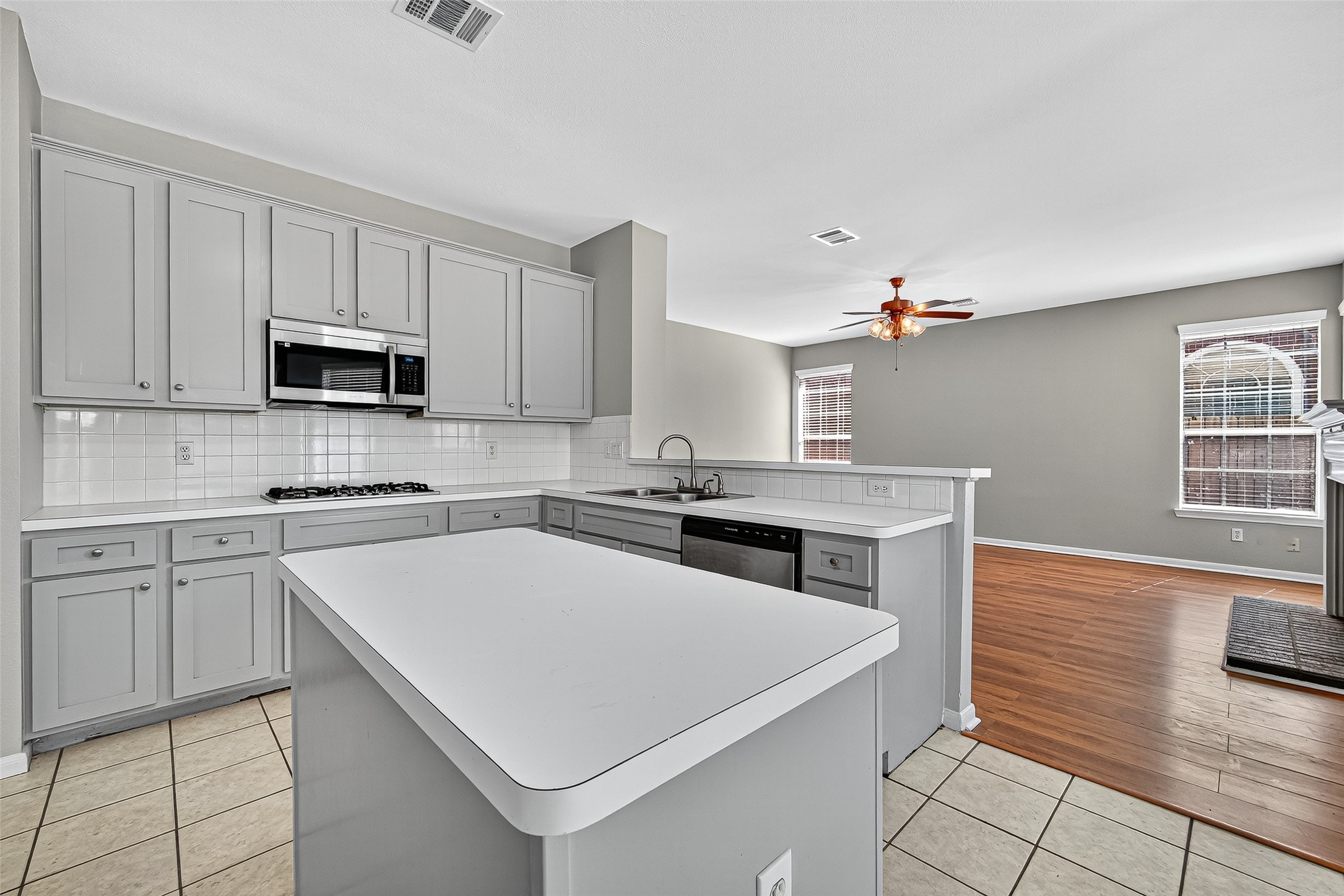 7411 Pacific Ridge Court Houston, TX 77095 - Photo 16 of 50 a kitchen with granite countertop a stove top oven a sink dishwasher and white cabinets with wooden floor