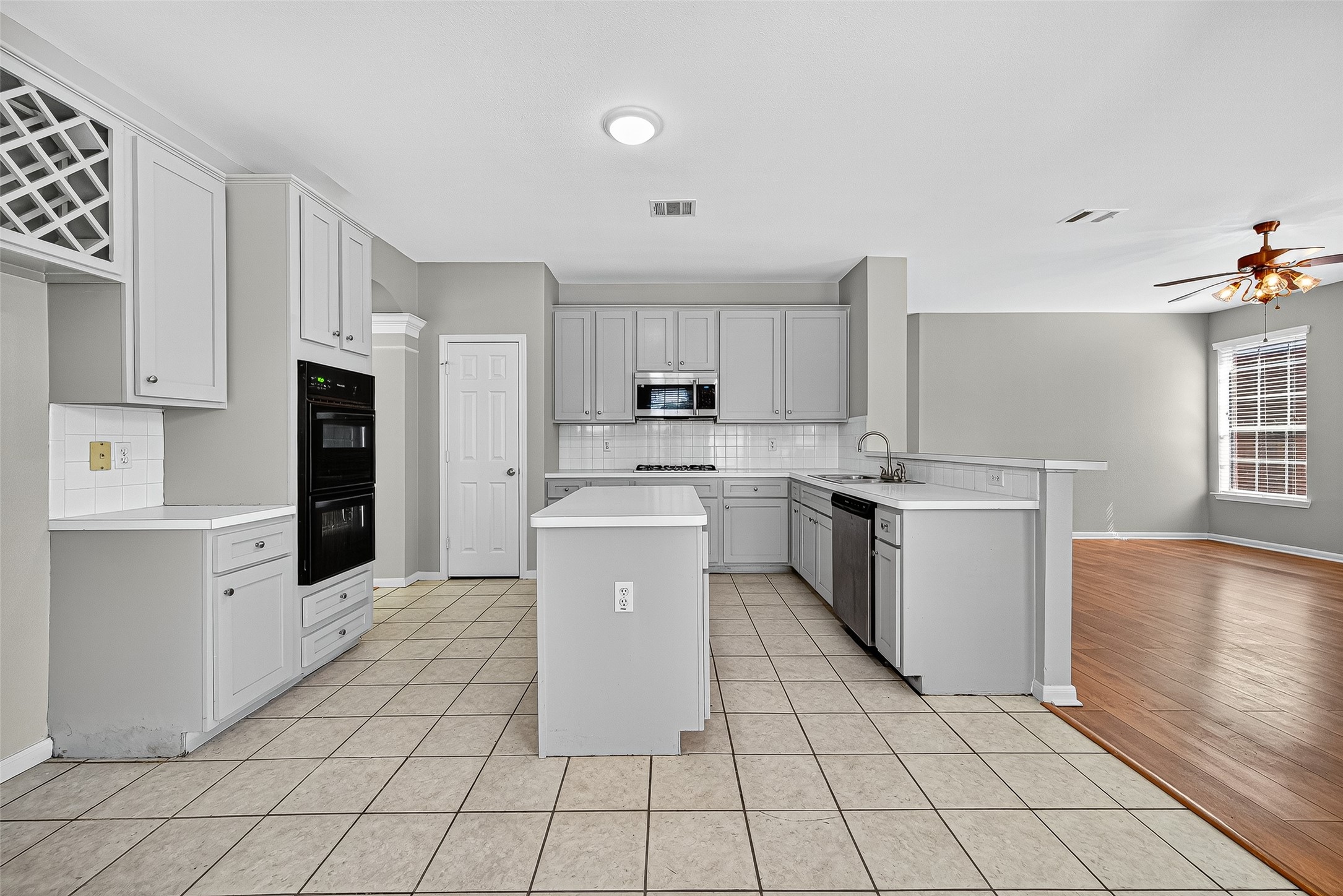 7411 Pacific Ridge Court Houston, TX 77095 - Photo 17 of 50 a kitchen with a sink a stove top oven and white cabinets