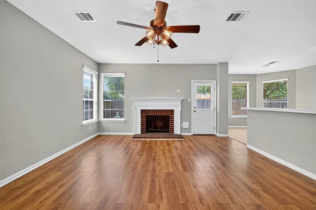 a view of a kitchen with a wooden floor and a ceiling fan