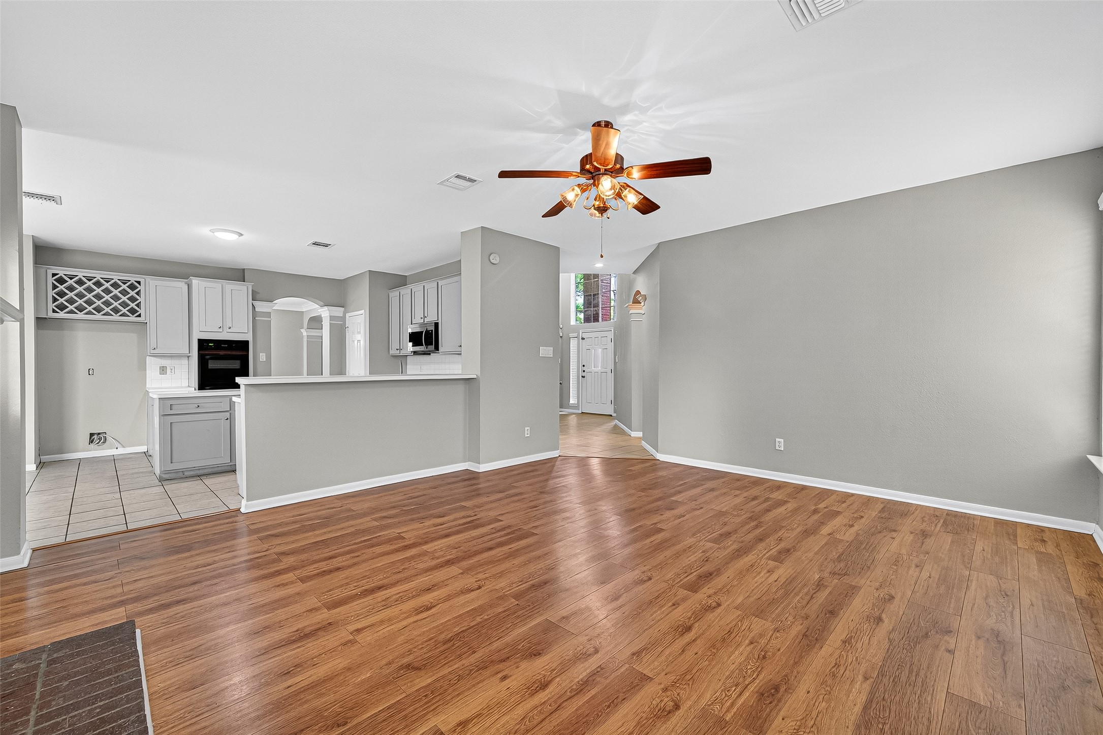 7411 Pacific Ridge Court Houston, TX 77095 - Photo 22 of 50 a view of a kitchen with a wooden floor and a ceiling fan