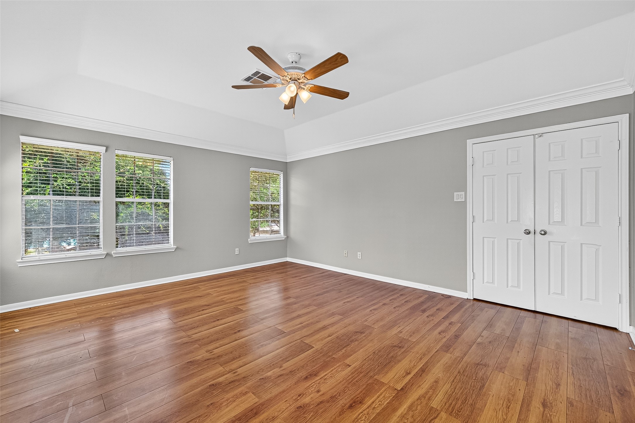 7411 Pacific Ridge Court Houston, TX 77095 - Photo 26 of 50 an empty room with wooden floor a ceiling fan and windows