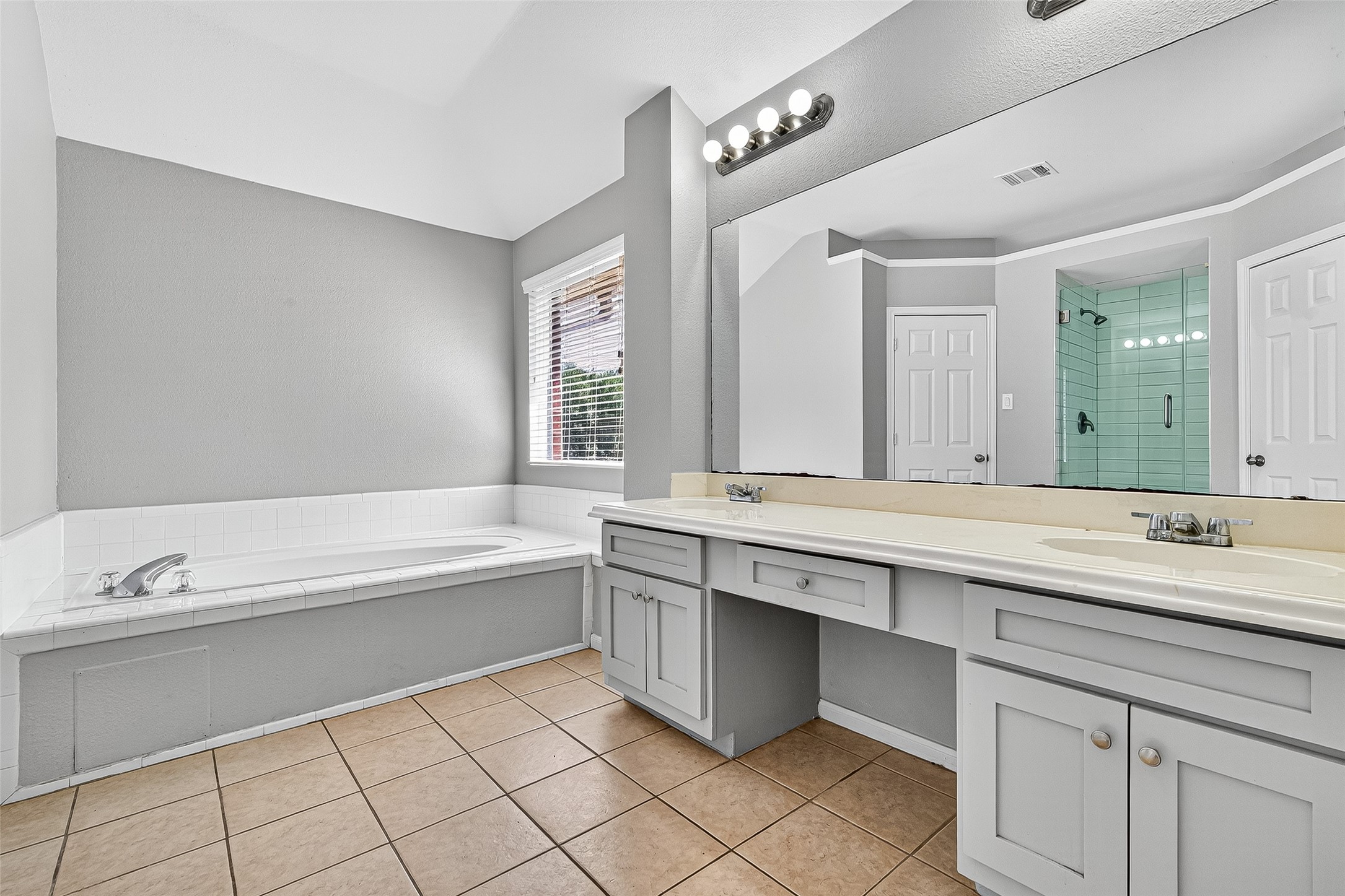 7411 Pacific Ridge Court Houston, TX 77095 - Photo 33 of 50 a bathroom with a sink a mirror and a bathtub