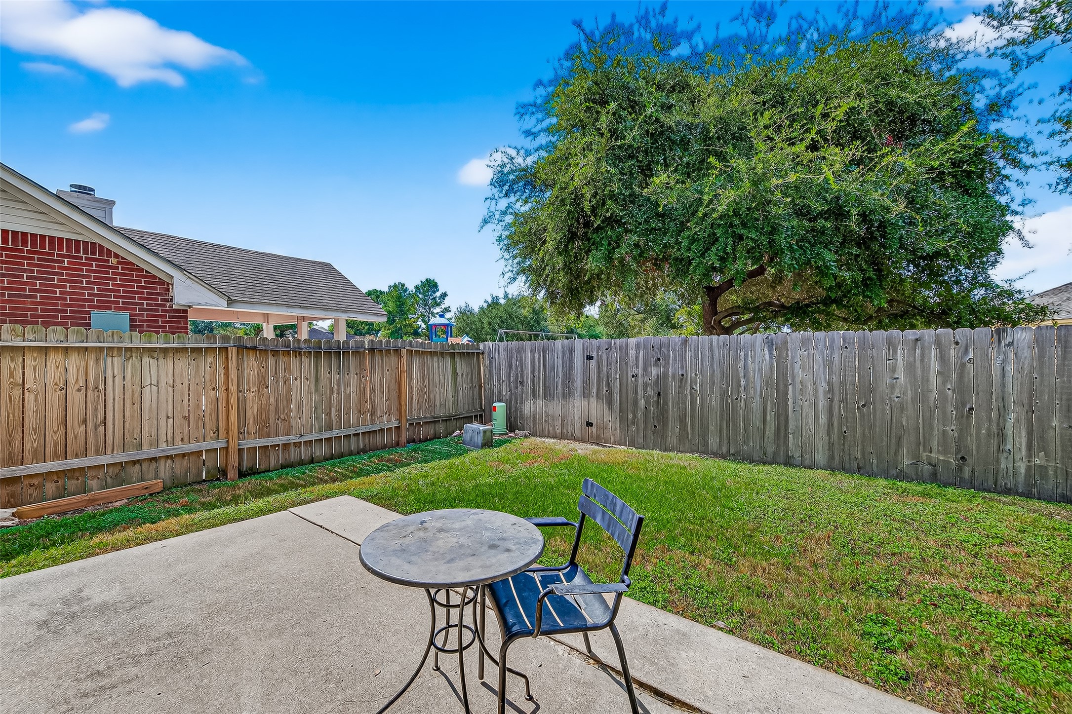 7411 Pacific Ridge Court Houston, TX 77095 - Photo 47 of 50 a view of a backyard with table and chairs with wooden fence