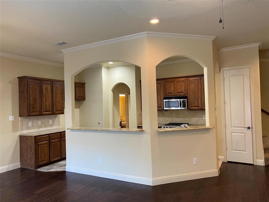 2222 Kirby Street Dallas, TX 75204 - Photo 17 of 25 Open-concept kitchen featuring rich wood cabinetry, stainless steel appliances, and a tile backsplash