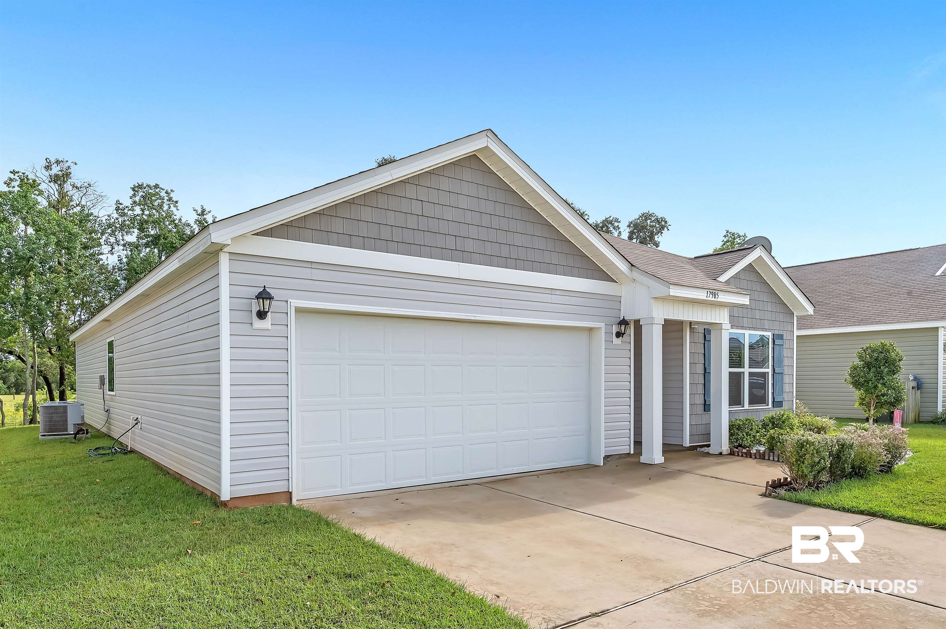 17985 Lewis Smith Drive Foley, AL 36535 - Photo 3 of 56 View of front facade with a garage, central AC unit, and a front lawn