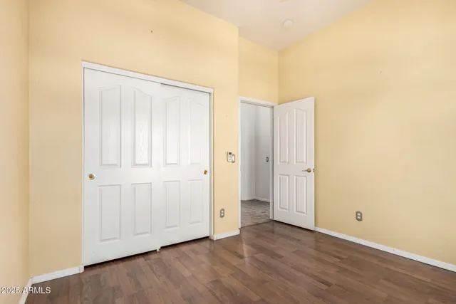 an empty room with a window and a chandelier fan