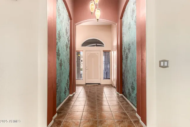 a view of a hallway with a chandelier and a livingroom
