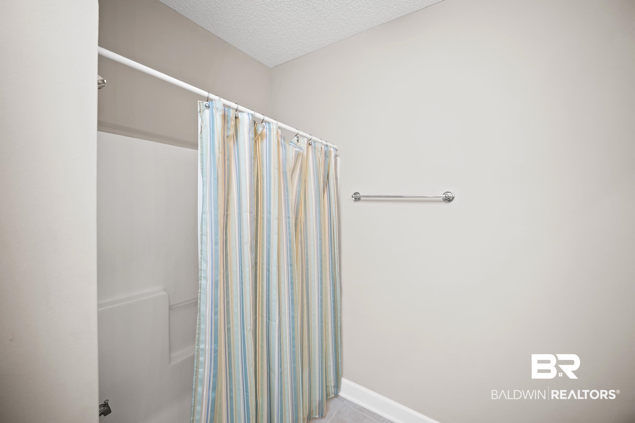 430 West Fort Morgan Road, Unit 704 Gulf Shores, AL 36542 - Photo 21 of 35 Bathroom featuring a built-in shower/tub combination, light-toned wall paint, and a chrome towel bar