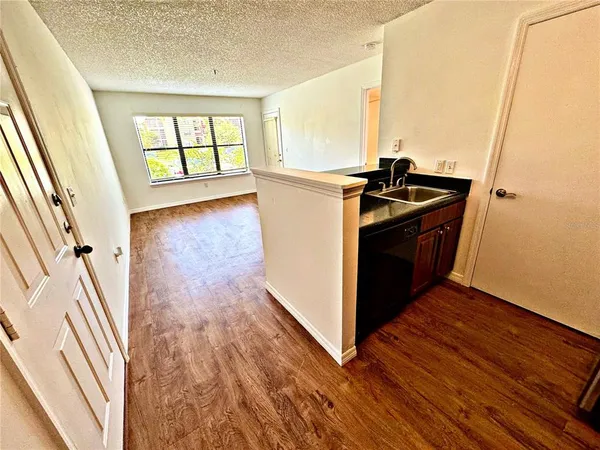 an empty room with wooden floor and a fireplace