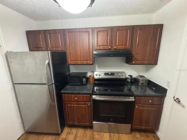 a kitchen with a refrigerator sink and cabinets