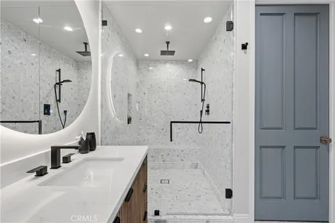 a bathroom with a double vanity sink mirror and shower