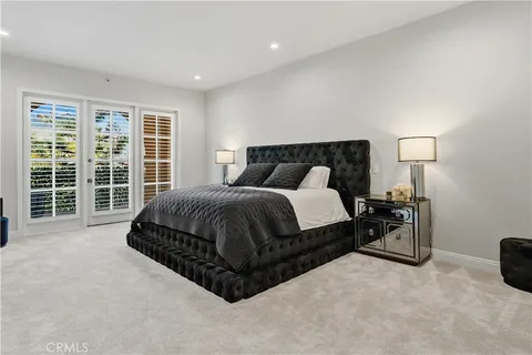 a spacious bedroom with a bed and wooden floor