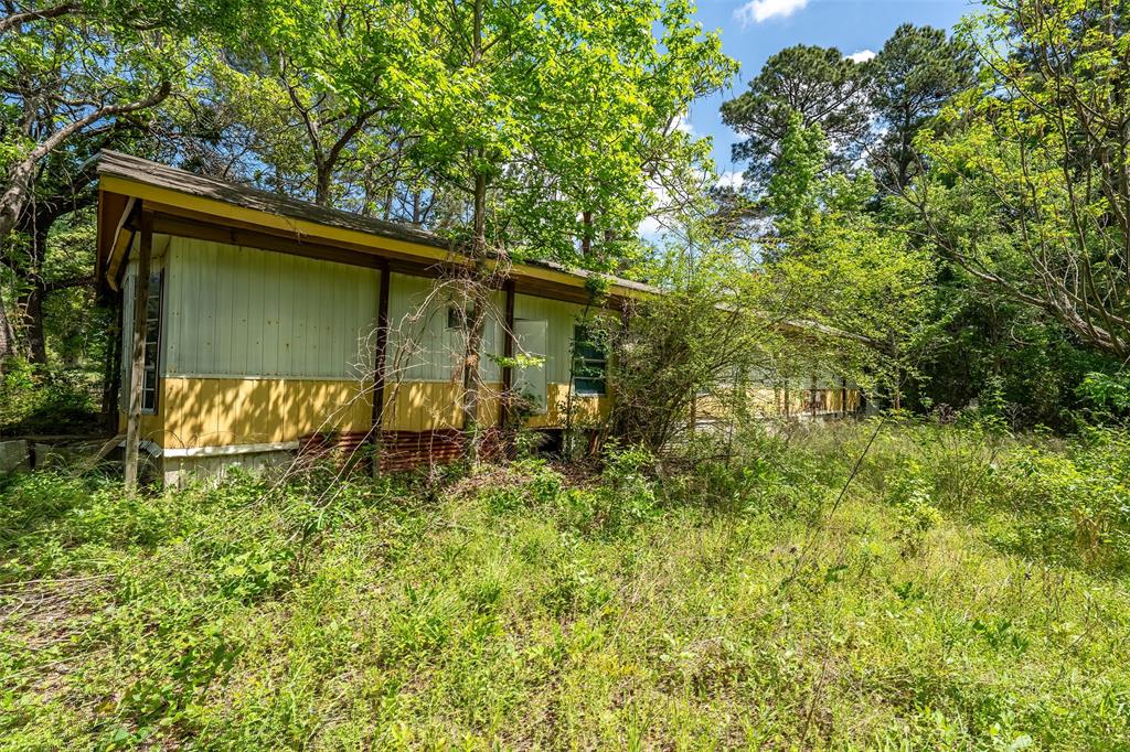 1532 Phillips Springs Road Gladewater, TX 75647 - Photo 16 of 19 a backyard of a house with lots of plants and entertaining space