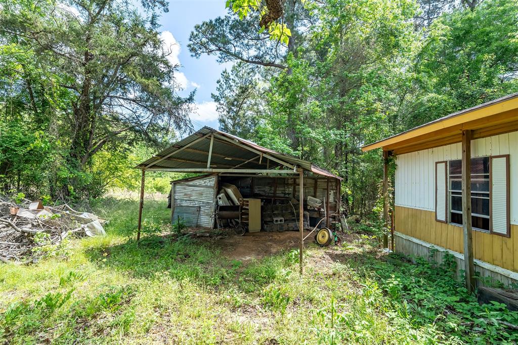 1532 Phillips Springs Road Gladewater, TX 75647 - Photo 17 of 19 a view of wooden house with a yard and large trees