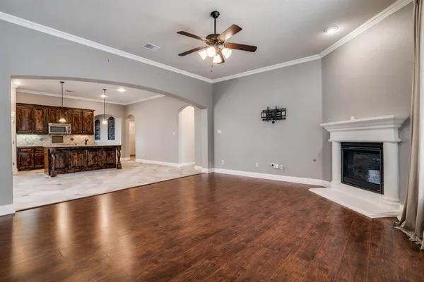 a view of an empty room with a fireplace and wooden floor