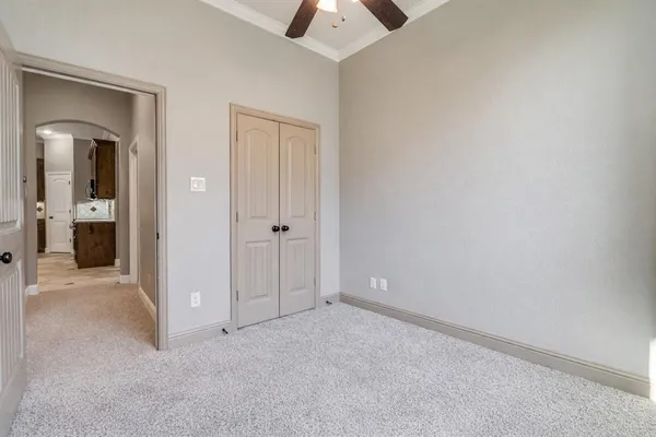 an empty room with chandelier fan