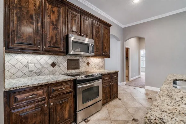 a kitchen with granite countertop wooden cabinets and stainless steel appliances