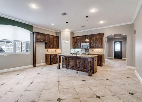 a kitchen with stainless steel appliances kitchen island granite countertop a refrigerator and cabinets