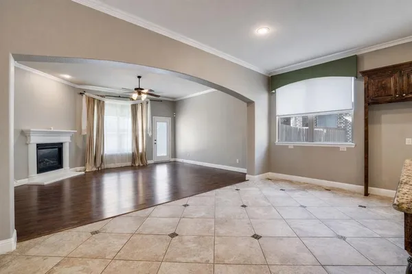an empty room with windows and fireplace