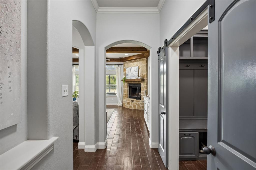 62 Trail Ridge Drive Melissa, TX 75454 - Photo 5 of 39 Beautiful entryway looking into the living room with wood beams, stone fireplace and the blue barn doors lead to the mudroom and 3 car garage