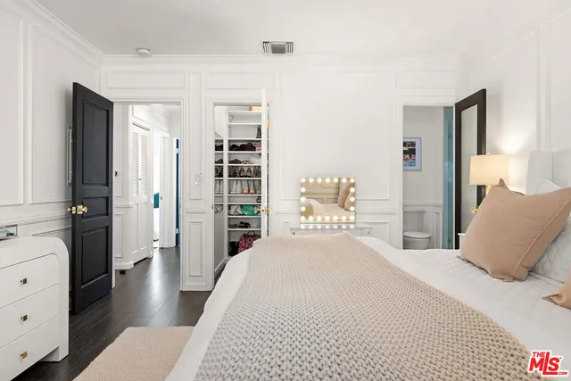 a bedroom with a large bed and wooden floor