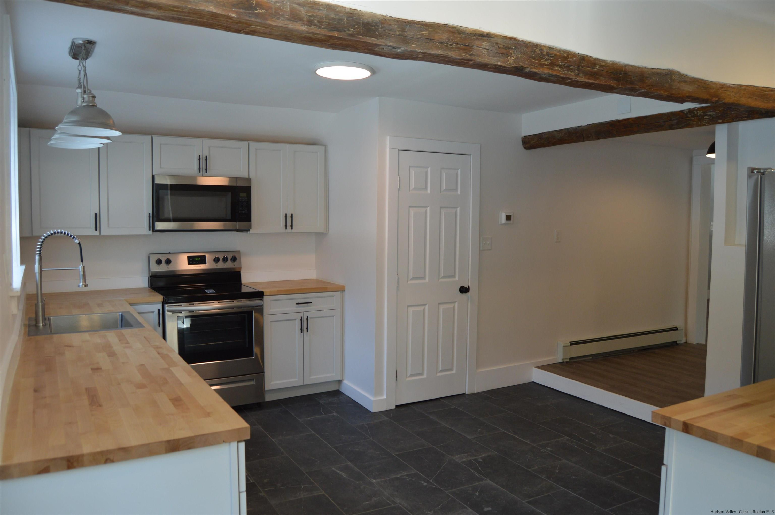 128 Cole Bank Road Saugerties, NY 12477 - Photo 6 of 26 a kitchen with granite countertop a stove and a sink