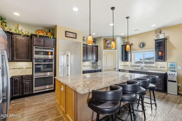 a kitchen with stainless steel appliances granite countertop a kitchen island a stove and a refrigerator