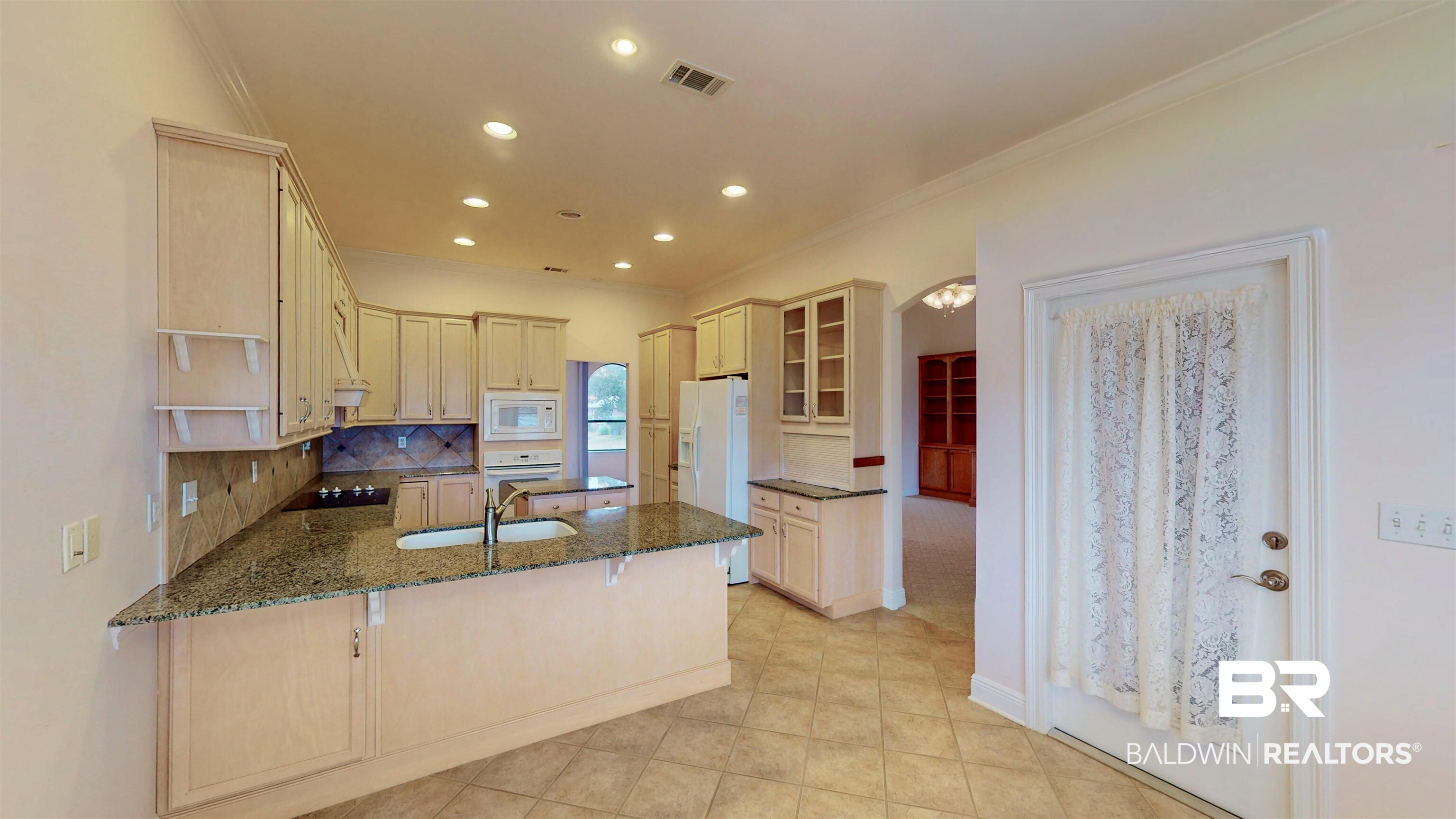 214 Hemingway Loop Foley, AL 36535 - Photo 11 of 67 Kitchen featuring a peninsula, a breakfast bar, crown molding, dark stone counters, and recessed lighting