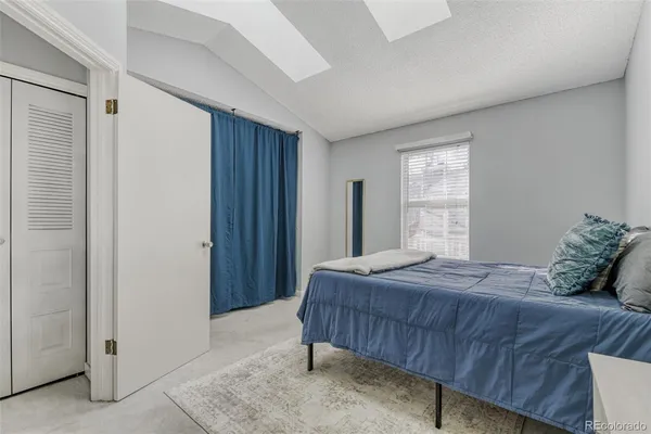 a bedroom with a bed a window and a mirror