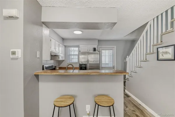 a kitchen with stainless steel appliances granite countertop a sink and a chair