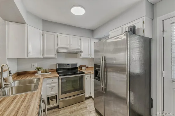 a kitchen with stainless steel appliances granite countertop a stove a refrigerator and a sink