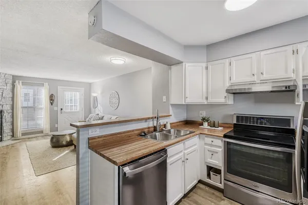 a kitchen with granite countertop a sink stove and cabinets