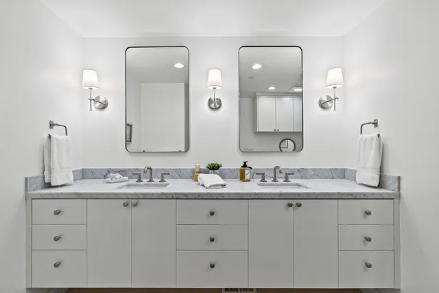 a bathroom with a granite countertop sink a toilet and shower