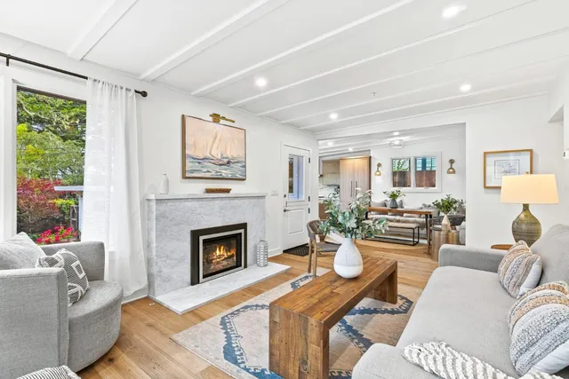 a living room with furniture a fireplace and a large window