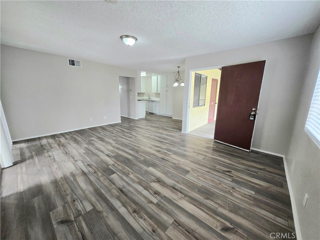 10979 Rincon Street Loma Linda, CA 92354 - Photo 3 of 13 a view of an empty room with wooden floor and a window