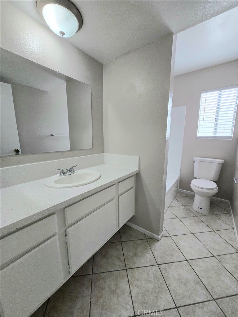 10979 Rincon Street Loma Linda, CA 92354 - Photo 10 of 13 a bathroom with a sink a toilet and a mirror
