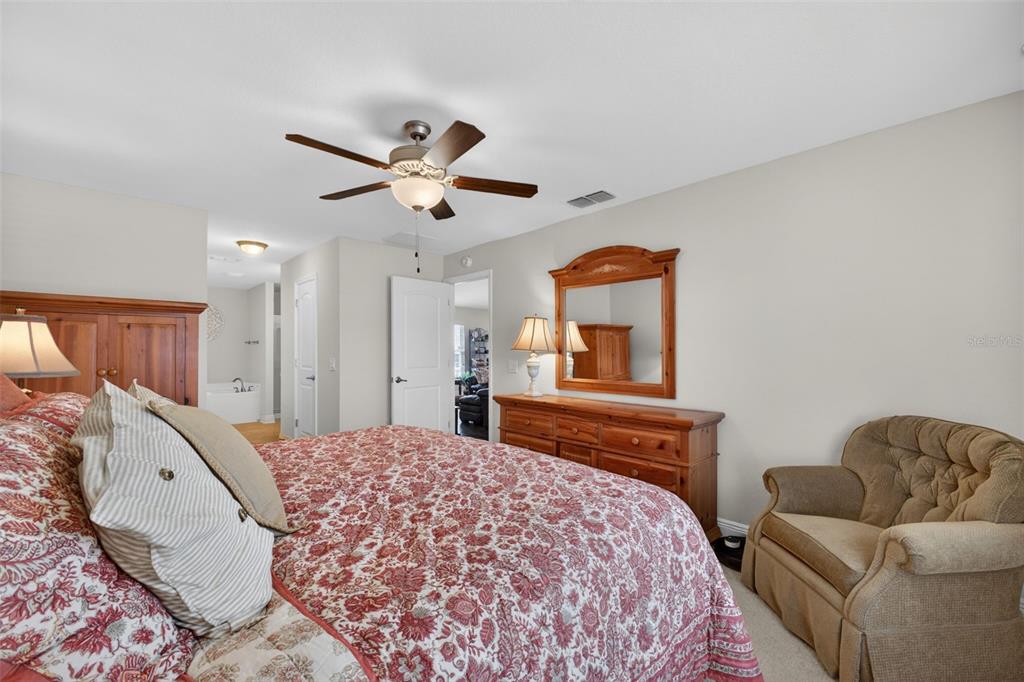 2429 Twin Lake View Road Winter Haven, FL 33881 - Photo 15 of 37 a bedroom with a bed a couch and a chandelier