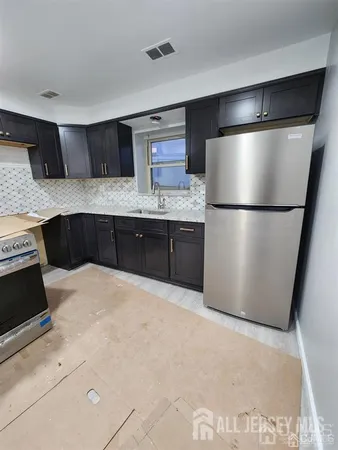 a kitchen with stainless steel appliances granite countertop a refrigerator a stove a sink and a refrigerator